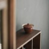 Ceramic teapot on wooden shelf