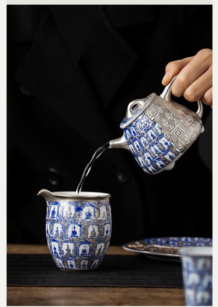 Pouring tea from patterned teapot into a cup