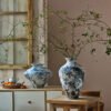 Artistic vases with branches on rustic furniture.