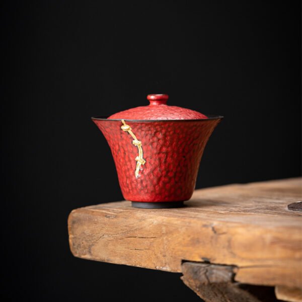 Red textured teacup with lid on wooden table