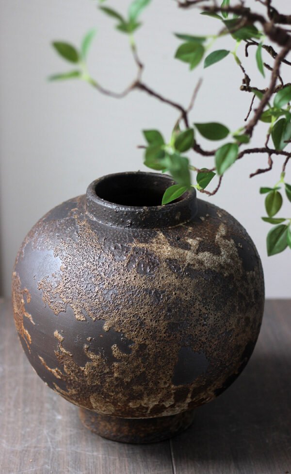 Rustic ceramic vase with green branch