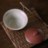 Ceramic teacup with lid on wooden tray