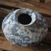 Blue speckled ceramic vase on wooden surface.