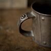 Close-up of a rustic metal mug handle.