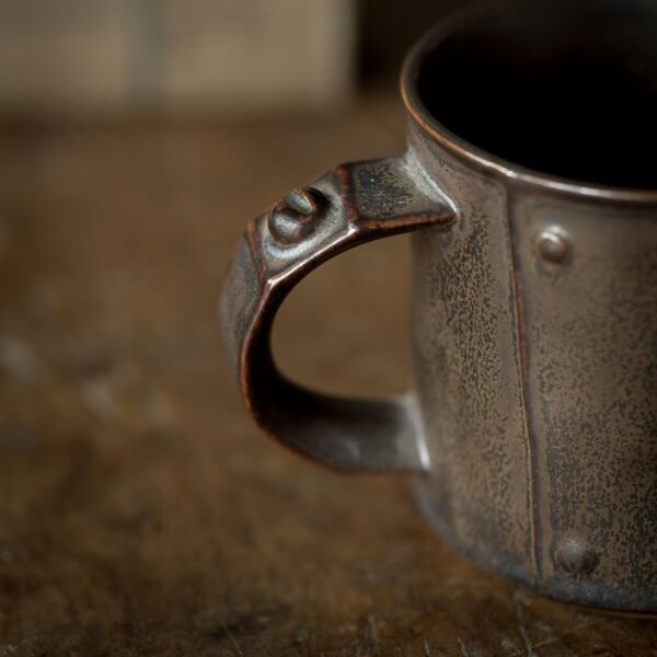 Close-up of a rustic metal mug handle.