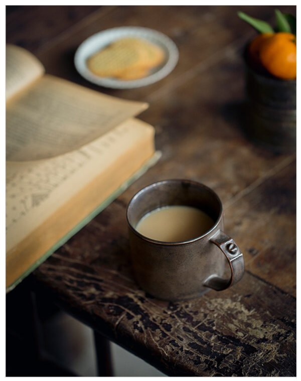 Tea with open book on rustic table