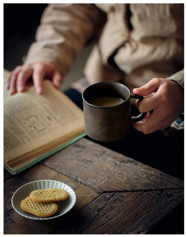 Person reading with coffee and cookies.