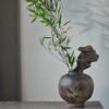 Rustic vase with bamboo and driftwood decoration.