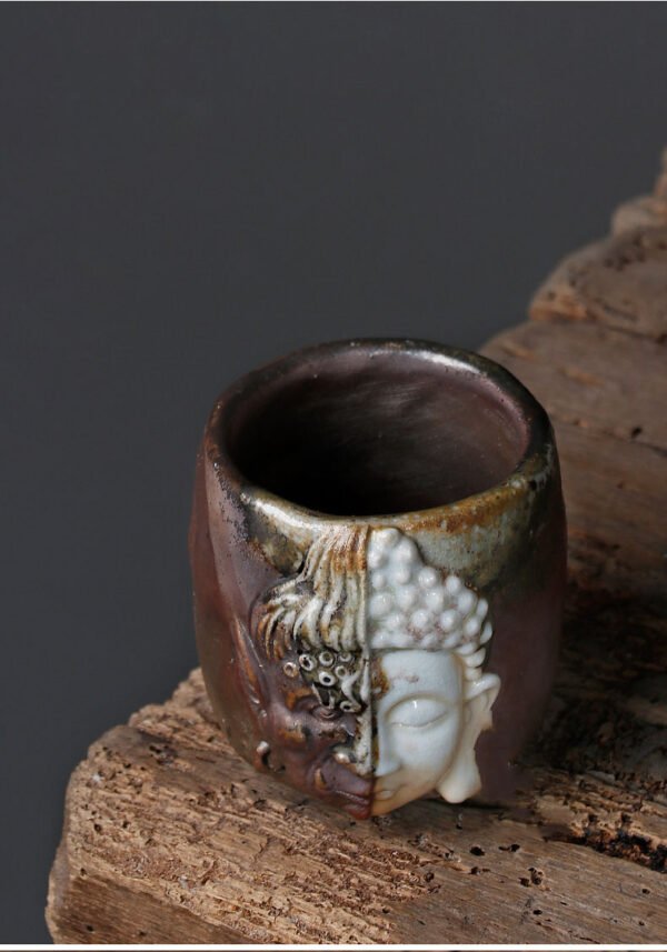 Buddha-themed ceramic cup on wooden table.