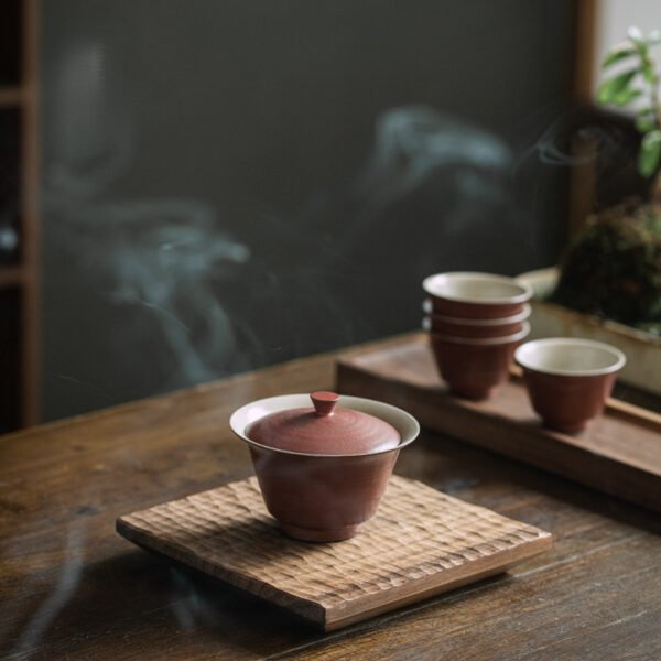 Ceramic teaware on wooden table with steam.