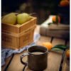 Cozy table setting with fruit and metal mug
