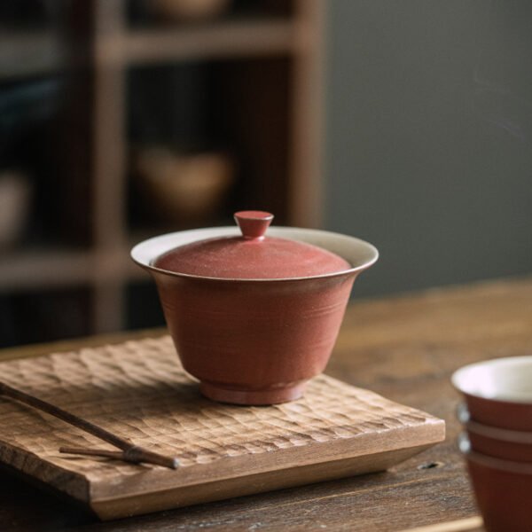 Red lidded teacup on wooden tray