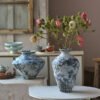 Rustic vases with flowers in vintage kitchen setting.