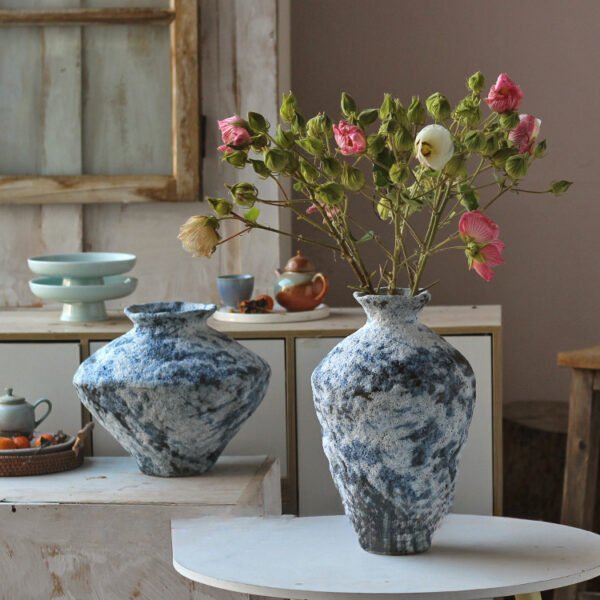 Rustic vases with flowers in vintage kitchen setting.