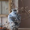 Decorative ceramic vase in rustic interior setting.