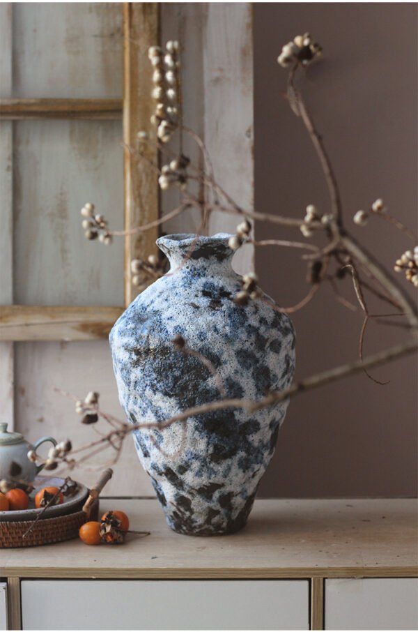 Decorative ceramic vase in rustic interior setting.